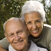 Happy looking elderly couple smiling and hugging